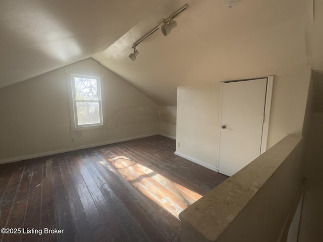 additional living space featuring dark hardwood / wood-style flooring and vaulted ceiling