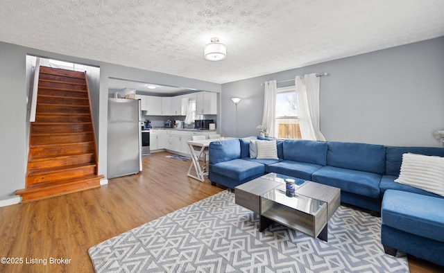 living room with light hardwood / wood-style floors and a textured ceiling