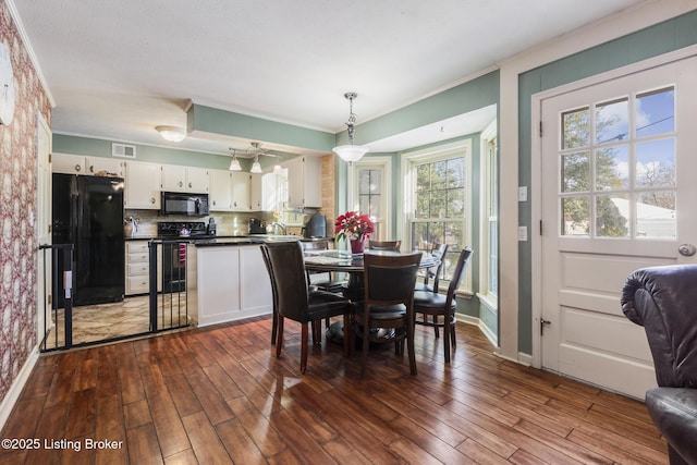 dining area with ornamental molding and dark hardwood / wood-style floors