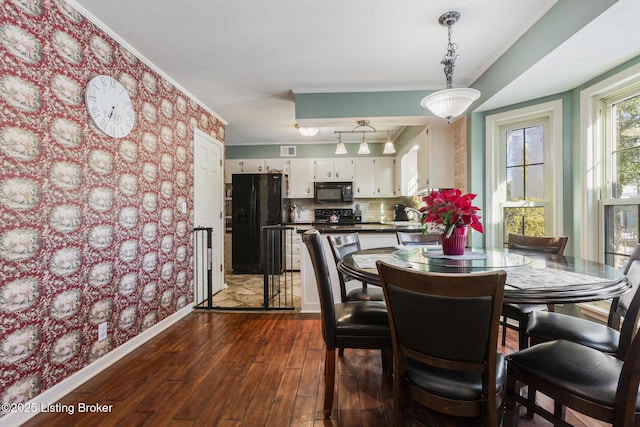 dining space with ornamental molding and dark hardwood / wood-style floors