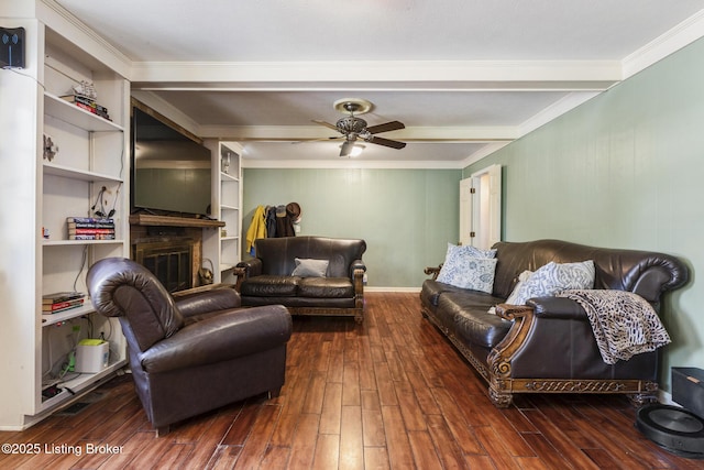 living room featuring beamed ceiling, ceiling fan, ornamental molding, dark hardwood / wood-style floors, and built in features