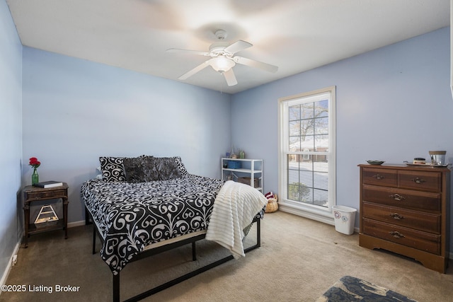 bedroom featuring ceiling fan, light carpet, and multiple windows