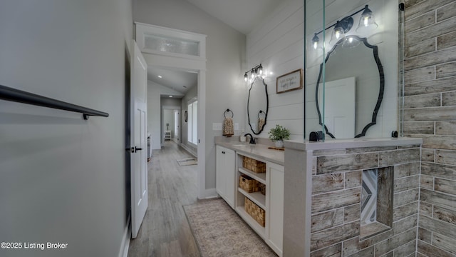 bathroom featuring vaulted ceiling, vanity, and wood-type flooring