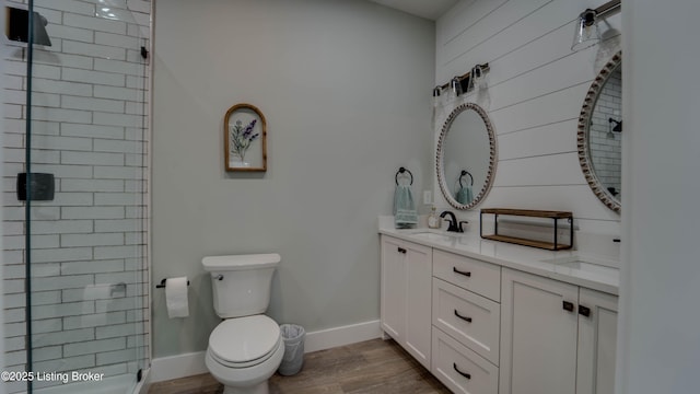 bathroom featuring walk in shower, vanity, hardwood / wood-style flooring, and toilet