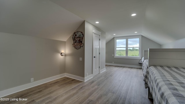 unfurnished bedroom featuring light hardwood / wood-style flooring and vaulted ceiling