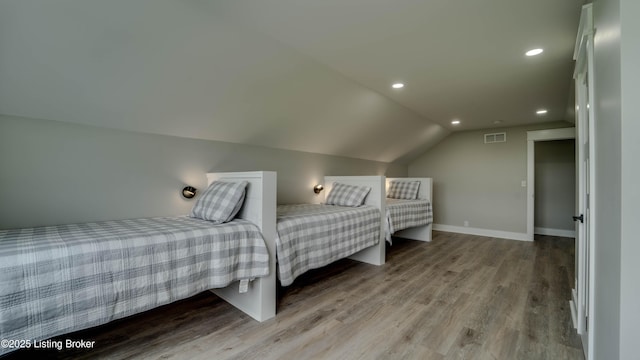 bedroom with lofted ceiling and light hardwood / wood-style floors