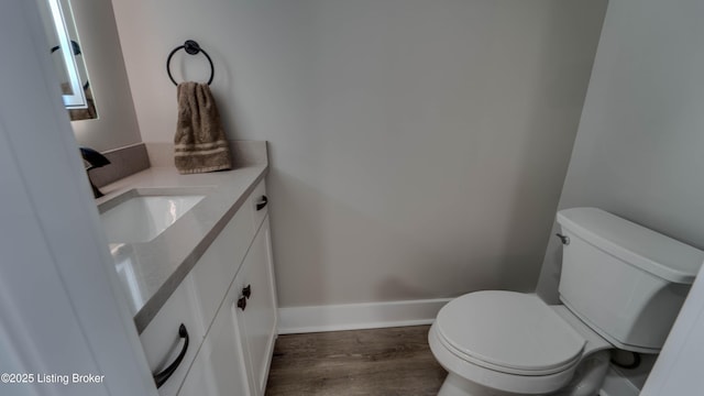 bathroom with toilet, vanity, and hardwood / wood-style floors