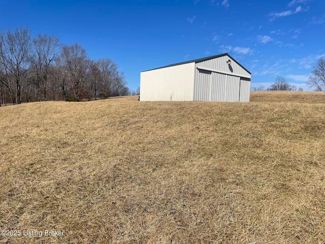 view of yard with a rural view and an outbuilding