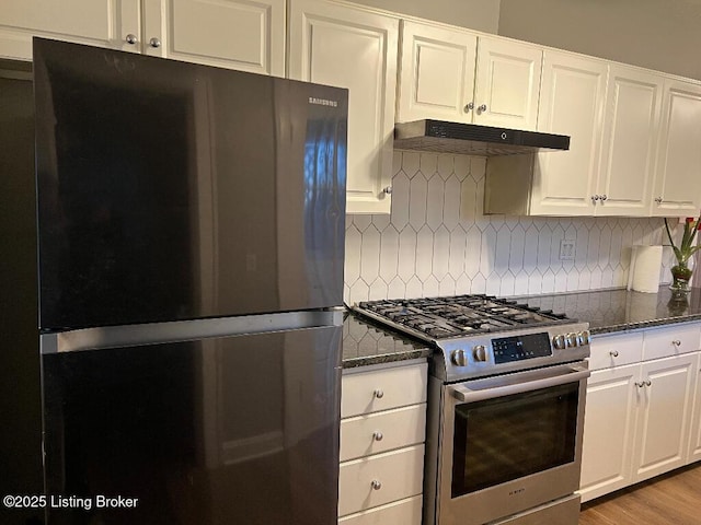 kitchen with backsplash, black fridge, dark stone counters, high end stainless steel range, and white cabinets