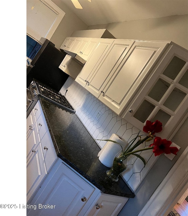 kitchen with white cabinets, tasteful backsplash, and dark stone countertops