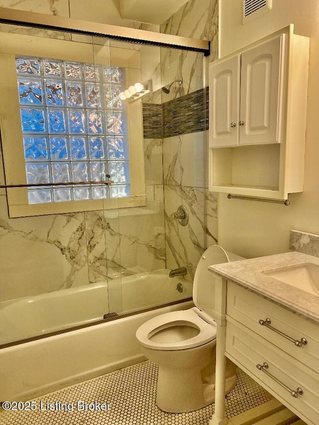 full bathroom featuring tile patterned flooring, vanity, enclosed tub / shower combo, and toilet