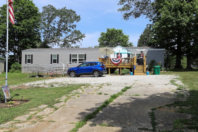 manufactured / mobile home featuring a front yard and a deck