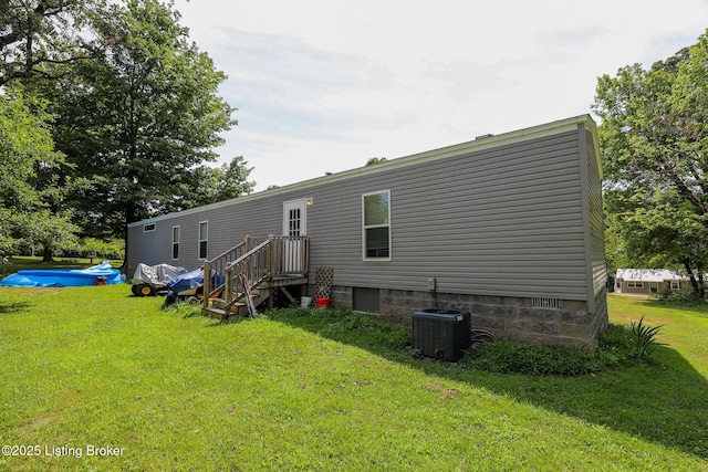 rear view of house featuring a lawn, cooling unit, and a pool