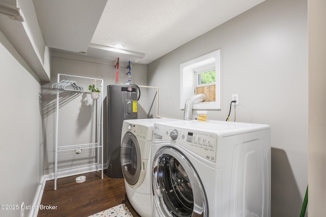 washroom with dark wood-type flooring, washer and clothes dryer, electric water heater, and a textured ceiling