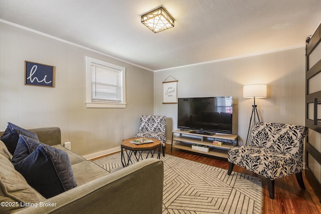 living room with hardwood / wood-style flooring, ornamental molding, and a textured ceiling