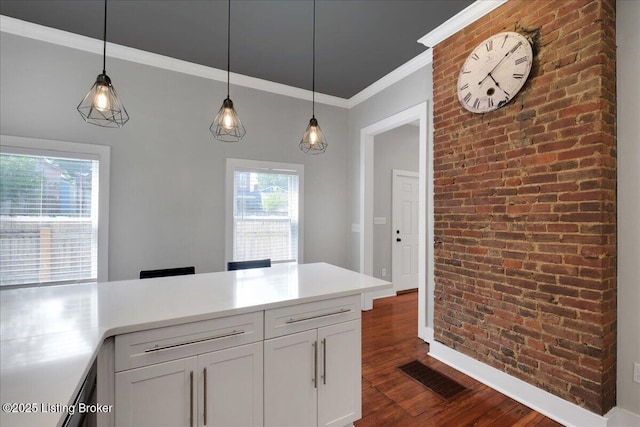 kitchen featuring hanging light fixtures, dark hardwood / wood-style floors, ornamental molding, white cabinetry, and brick wall