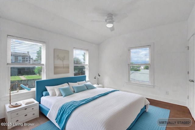 bedroom featuring hardwood / wood-style floors, vaulted ceiling, and ceiling fan