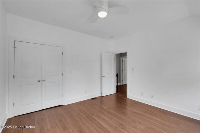 unfurnished bedroom featuring ceiling fan, a closet, and hardwood / wood-style flooring