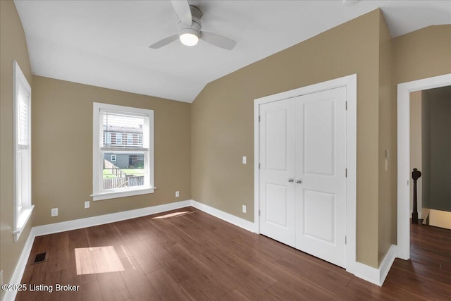 unfurnished bedroom with dark hardwood / wood-style flooring, a closet, ceiling fan, and lofted ceiling