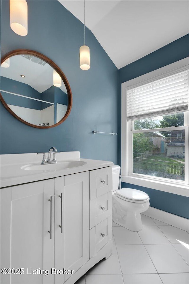 bathroom with tile patterned floors, vanity, vaulted ceiling, and toilet