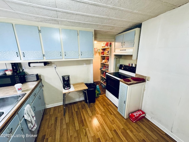 kitchen featuring white electric range oven, dark wood-type flooring, and sink