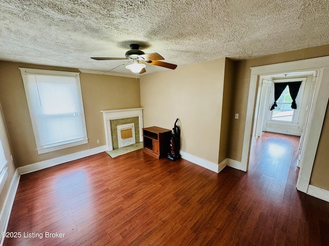 unfurnished living room with a textured ceiling, ceiling fan, and dark hardwood / wood-style floors