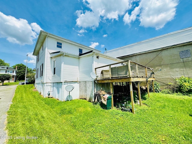 back of house with a wooden deck and a yard