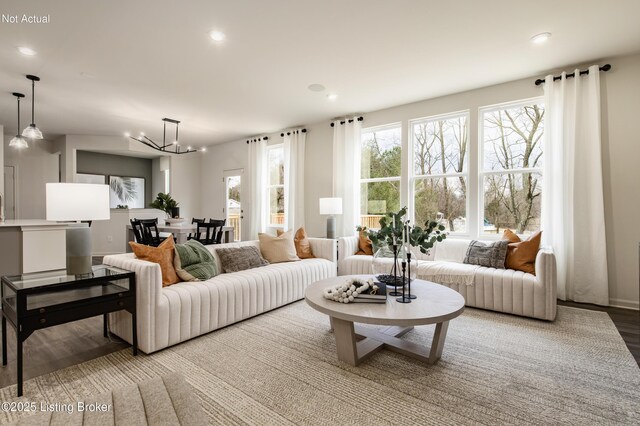 living room featuring wood-type flooring and an inviting chandelier