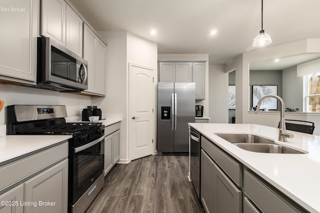 kitchen with sink, hanging light fixtures, gray cabinets, dark hardwood / wood-style flooring, and stainless steel appliances