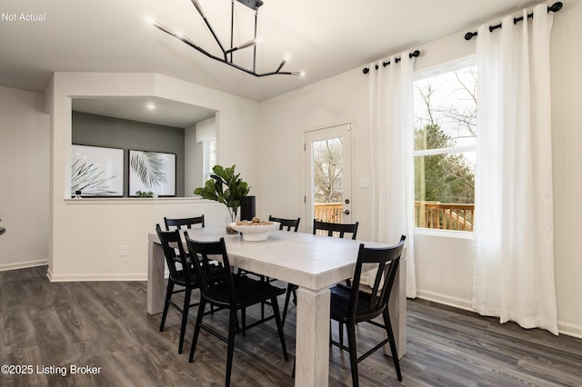 dining space featuring dark hardwood / wood-style flooring and a notable chandelier