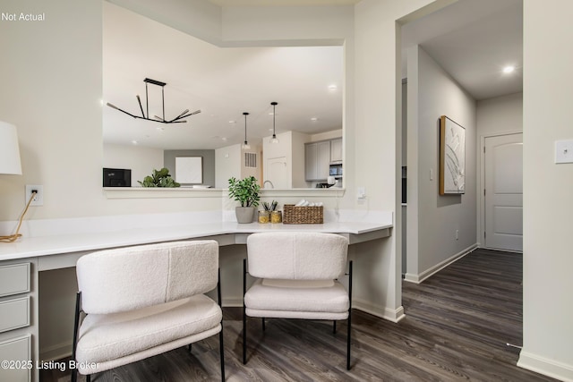 kitchen with decorative light fixtures, dark hardwood / wood-style flooring, and a chandelier