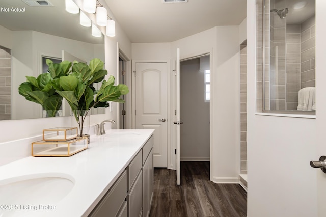 bathroom featuring hardwood / wood-style floors, vanity, and walk in shower