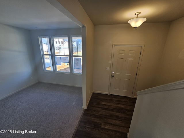 foyer entrance featuring dark wood finished floors and baseboards