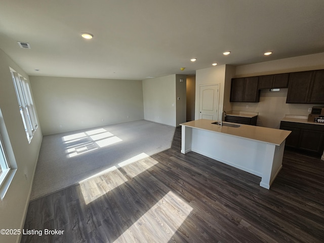 kitchen featuring dark wood finished floors, a sink, dark brown cabinets, and recessed lighting