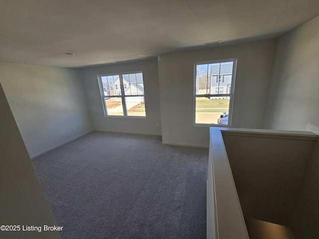 carpeted empty room featuring visible vents and baseboards