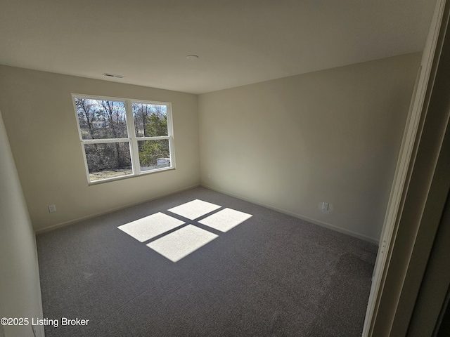 unfurnished room featuring carpet floors, visible vents, and baseboards