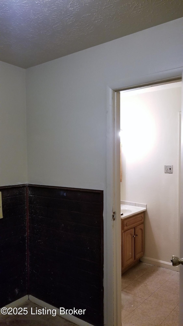 bathroom featuring vanity, tile patterned floors, and a textured ceiling