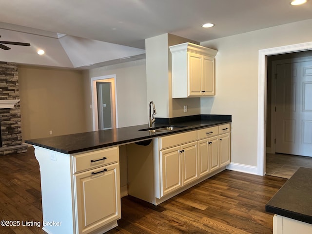 kitchen with kitchen peninsula, sink, and dark wood-type flooring