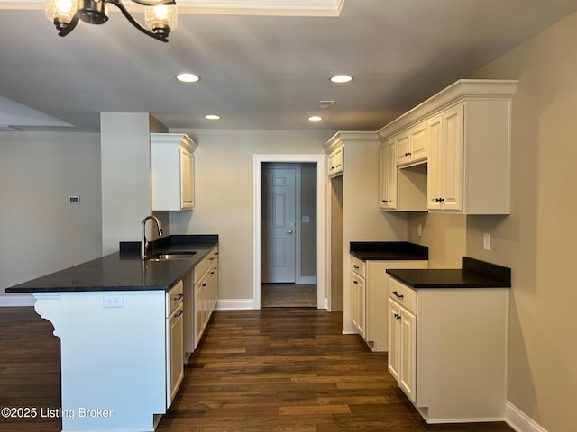 kitchen with kitchen peninsula, white cabinetry, sink, and dark wood-type flooring