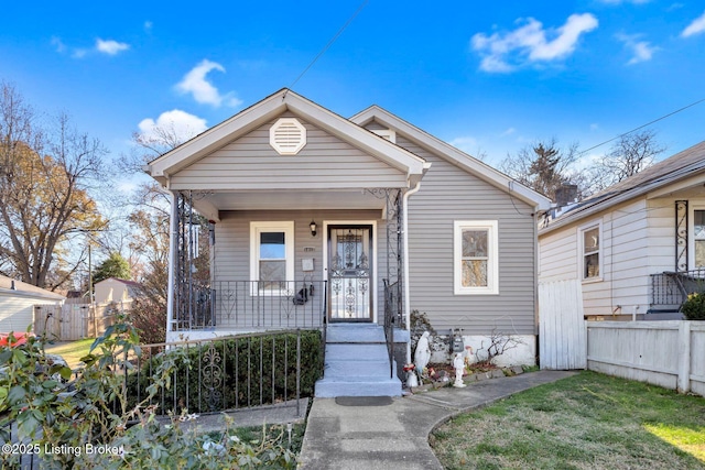 bungalow-style home with covered porch and a front lawn