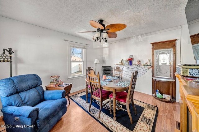 dining room featuring ceiling fan, light hardwood / wood-style flooring, and a textured ceiling