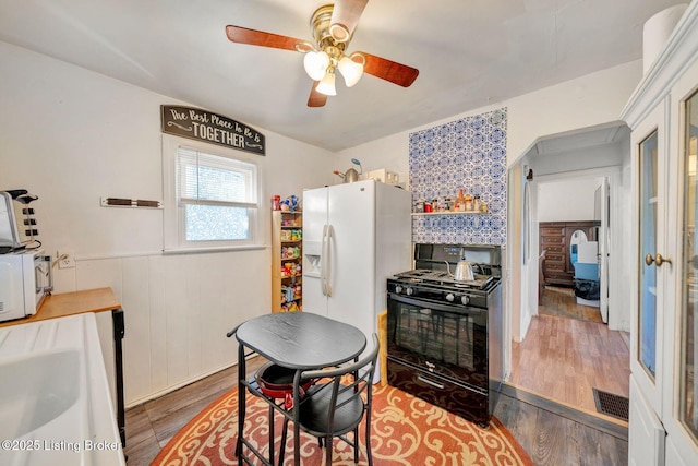 kitchen featuring wood-type flooring, white appliances, and ceiling fan