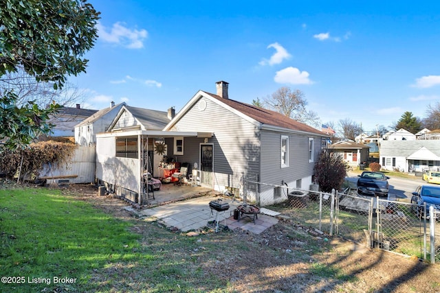 back of house featuring a lawn and a patio area