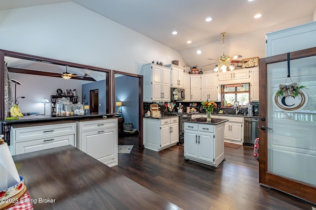 kitchen featuring a center island, white cabinets, decorative backsplash, dark hardwood / wood-style floors, and stainless steel appliances