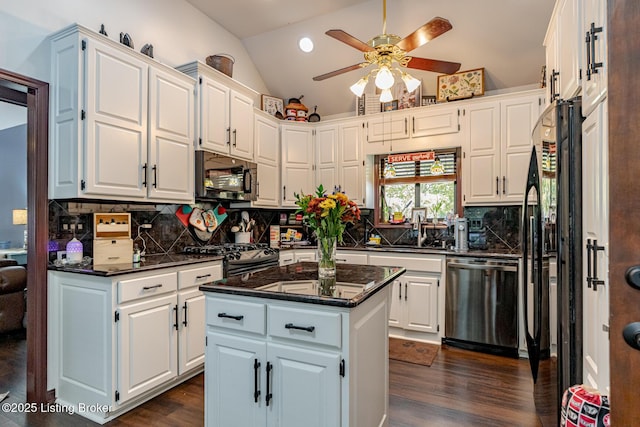 kitchen with a center island, white cabinetry, stainless steel dishwasher, and vaulted ceiling