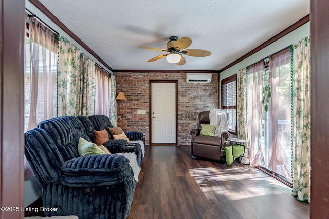 living room featuring a wall mounted air conditioner, brick wall, a textured ceiling, ceiling fan, and dark wood-type flooring