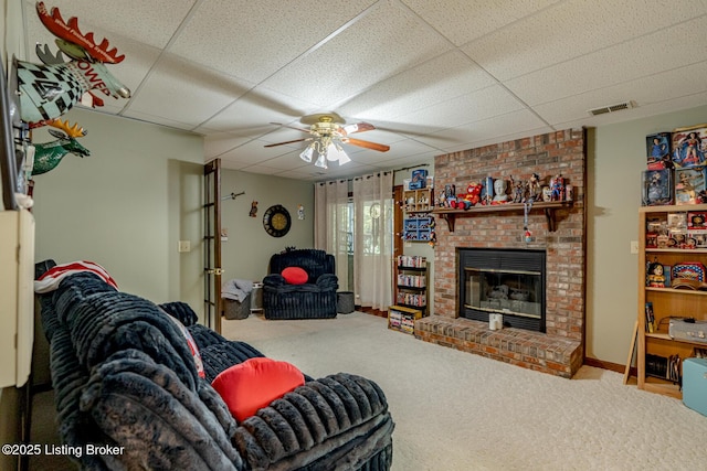 living room with a fireplace, a paneled ceiling, carpet floors, and ceiling fan