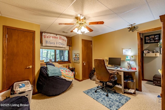 carpeted office with a drop ceiling and ceiling fan