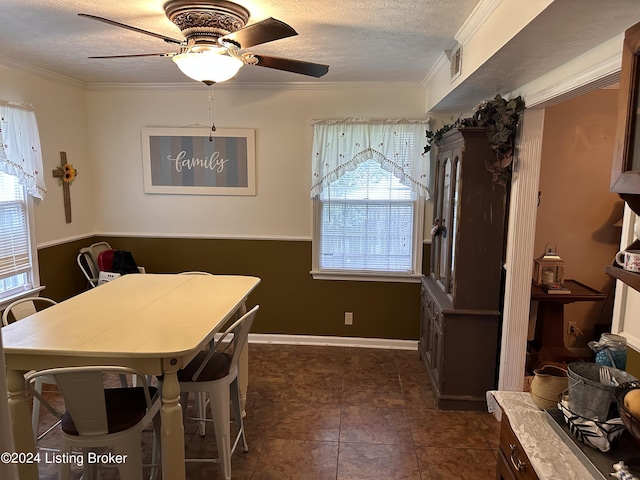 dining space featuring crown molding, ceiling fan, and a textured ceiling