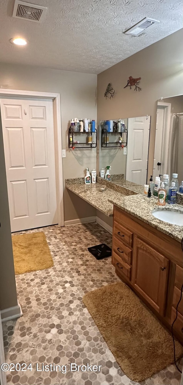 bathroom with vanity and a textured ceiling